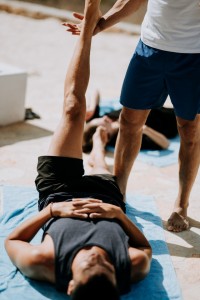 man helping another man stretch